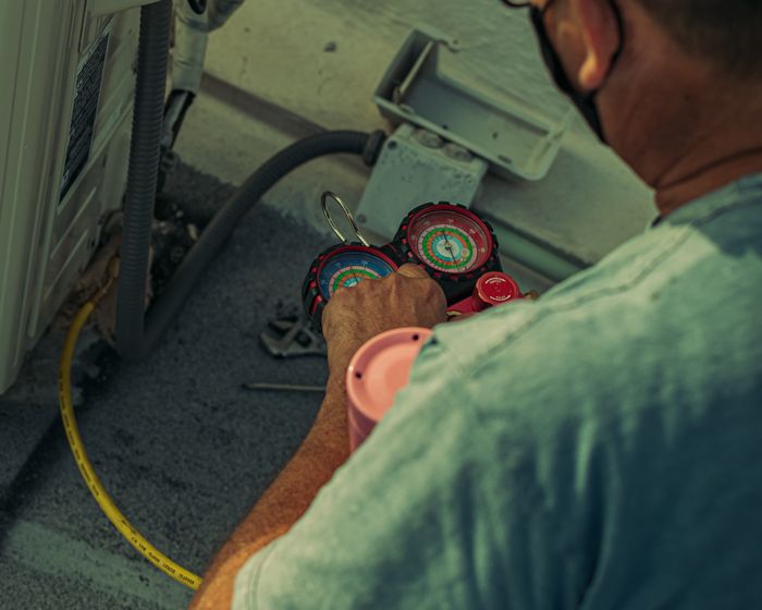 A technician servicing an AC unit.