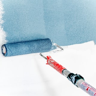 A painter rolling a wall.